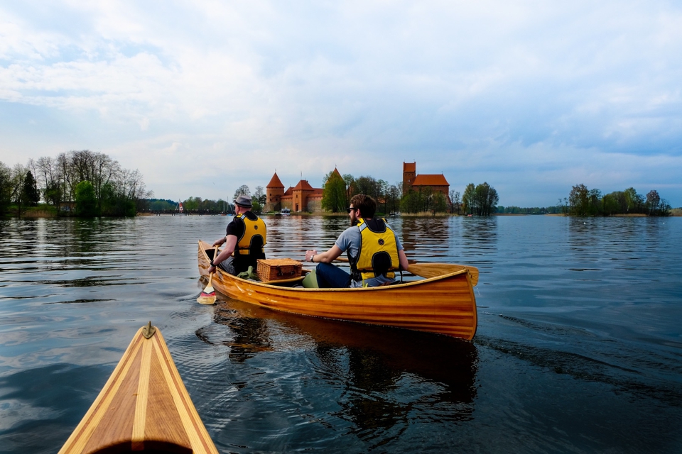 Friends paddling towards castle in Trakai, Llithuania