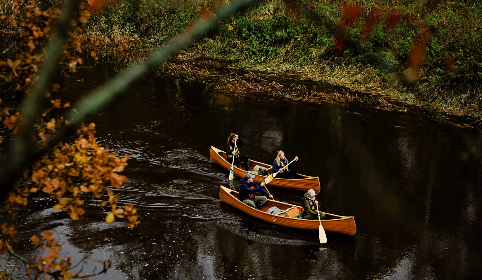 Two cedar strip canoes down the river