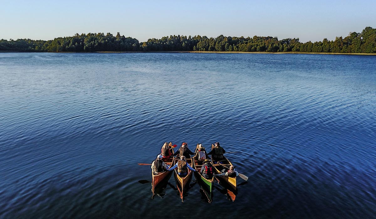 Four canoes stuck together during Crystal Waters tour in lake Plateliai